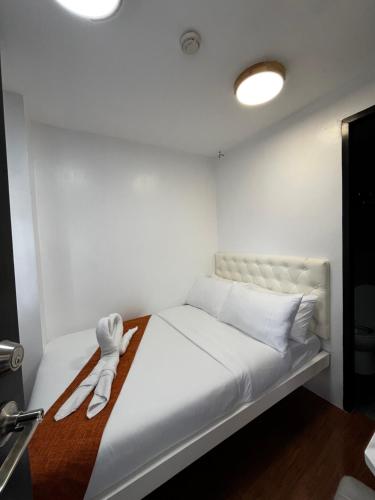 a white bed with two white towels on it at Rangya Hotel in Tagaytay