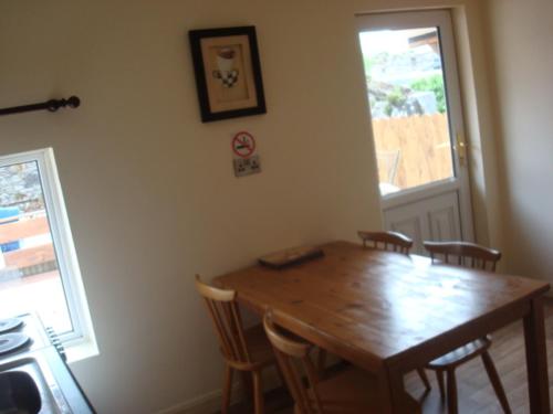 a dining room with a wooden table and chairs at Swinford Bridge Street Apartment in Swinford