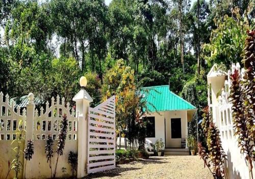 a white fence in front of a house at Mist Nest Munnar in Munnar