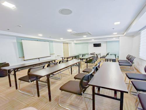 a classroom with desks and chairs and a whiteboard at Red Planet Cagayan De Oro in Cagayan de Oro