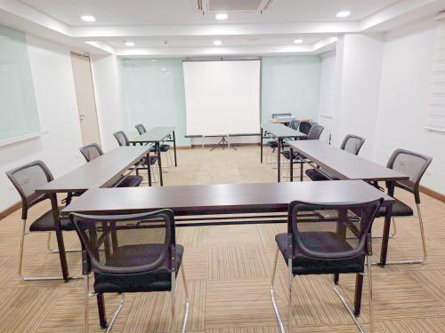 a conference room with tables and chairs and a whiteboard at Red Planet Cagayan De Oro in Cagayan de Oro
