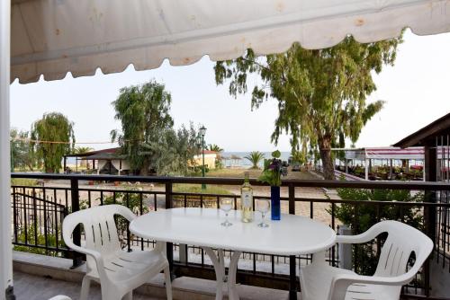 a white table and chairs on a balcony at Seaside Studios in Paralia Dionysiou