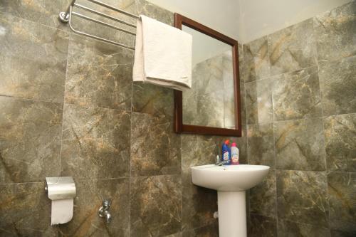 a bathroom with a sink and a mirror at Traget safari home stay in Udawalawe