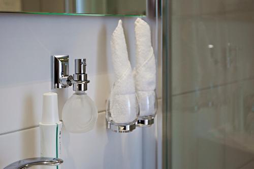 a bathroom with a towel dispenser and a sink at Hotel Garni Ammergauer Hof in Oberammergau