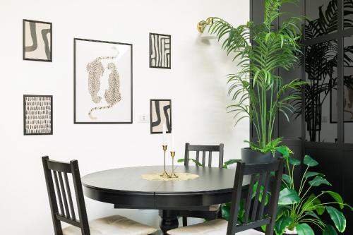 a dining room with a table and chairs and plants at Tranquility Inn- 25 min Duomo M1 in Sesto San Giovanni