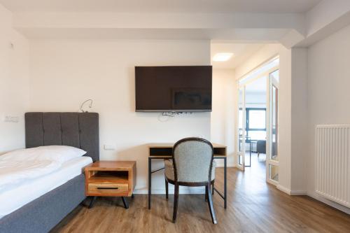 a bedroom with a bed and a desk with a chair at Aalto Hotel in Hannover