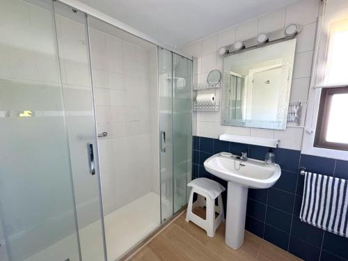 Un baño con ducha de cristal y lavabo. en Albaida Parque, en Benidorm