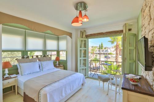 a bedroom with a bed and a balcony at Palas Alaçatı - Adult Only in Alacati