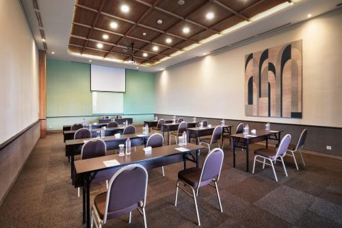 a classroom with tables and chairs in a room at Luwansa Hotel and Convention Center Manado in Manado