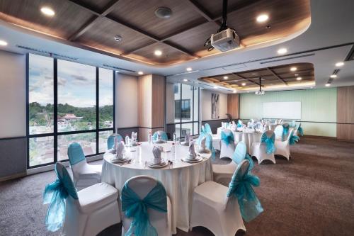 a conference room with tables and chairs with blue bows at Luwansa Hotel and Convention Center Manado in Manado