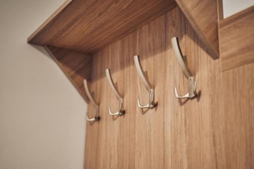 a wooden cabinet with metal hooks on it at Hotel Lilia in Włoszczowa