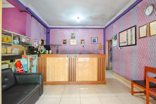 a bar in a restaurant with purple walls at RedDoorz near Kopeng Salatiga 
