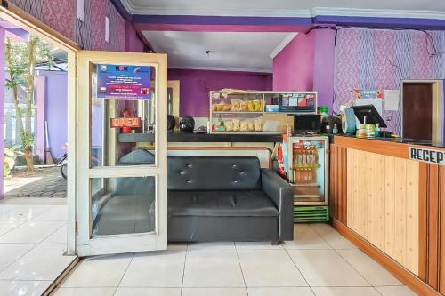 a restaurant with a black leather bench in a room at RedDoorz near Kopeng Salatiga 