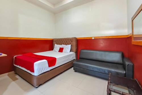 a small bedroom with a bed and a chair at RedDoorz near Kopeng Salatiga 