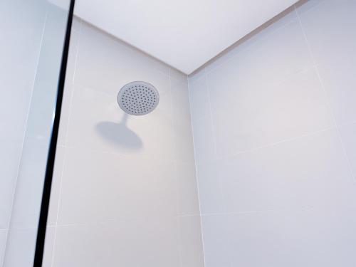 a shower in a white room with a ceiling at Red Planet Clark Angeles City in Angeles