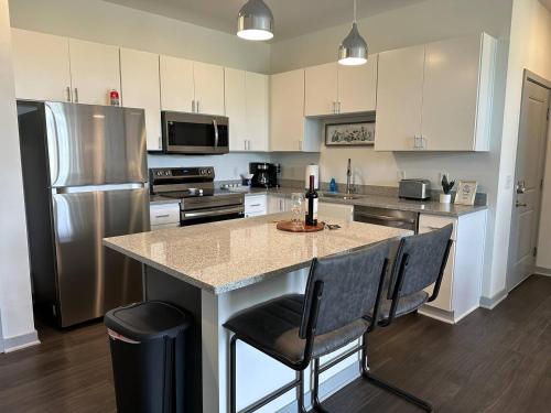 a kitchen with a large island with chairs and a refrigerator at Spotless Remote Work Flat Pool Fast Wifi in Dublin