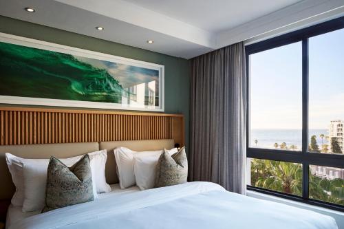 a bedroom with a large bed and a large window at President Hotel in Cape Town