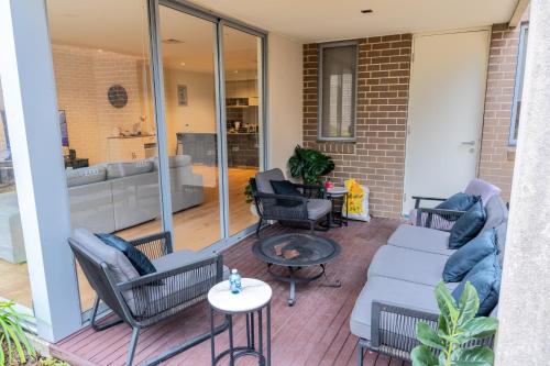 バンドゥーラにあるShared House in Melbourneのソファと椅子とテーブルのあるパティオ
