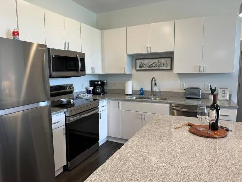 a kitchen with white cabinets and stainless steel appliances at Spotless Remote Work Flat Pool Fast Wifi in Dublin