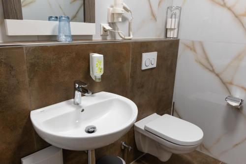 a bathroom with a sink and a toilet at Aalto Hotel in Hannover