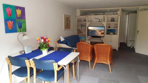 a dining room with a table and chairs and a couch at Appartement in Zandvoort in Zandvoort