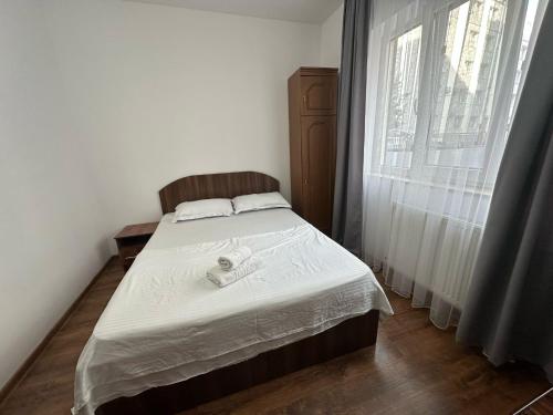 a small bedroom with a bed with white sheets at Zlata Nordic Residence 16a in Suceava