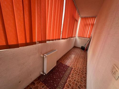 a hallway with an orange curtain and a radiator at Zlata Nordic Residence 16a in Suceava