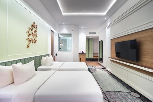 a hotel room with two beds and a flat screen tv at Luwansa Hotel and Convention Center Manado in Manado