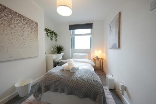 a bedroom with a bed and a window at Cozy Urban Escape 2BR near Greenwich & Deptford in London