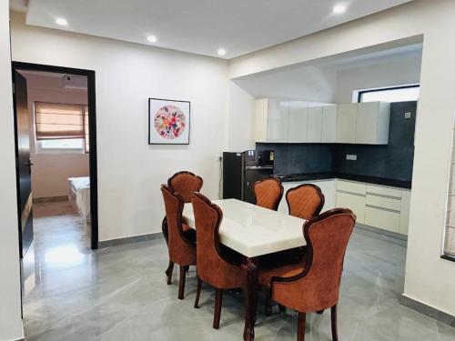 a kitchen with a white table and chairs at Lavish Apartments with Pool Candolim Luxfort in Candolim