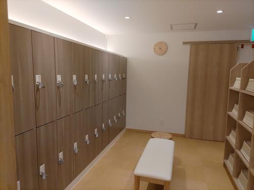 a locker room with wooden lockers and a bench at Hotel Yumeshizuku in Minami Aso