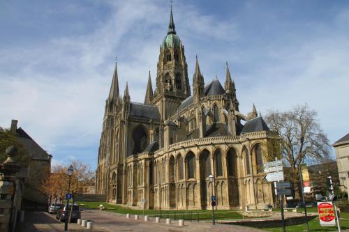 a large building with a church with a tower at Hôtel Le Bayeux in Bayeux