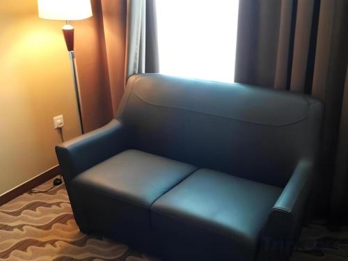 a blue chair in a room with a window at Eminent Hotel in Kota Kinabalu