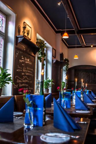 a dining room with blue tables and a chalkboard at Hotel Blaue Ecke in Adenau