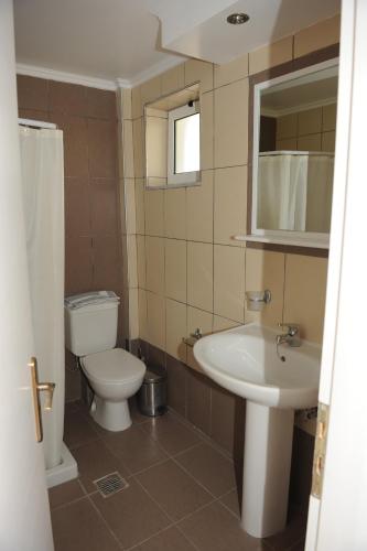a bathroom with a white toilet and a sink at Jenny Hotel in Laganas