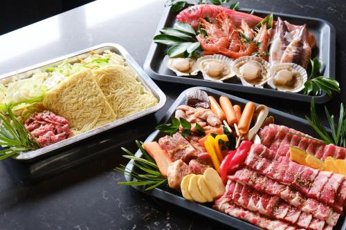 three trays of different types of food on a table at Little Deer by SANA in Tateyama