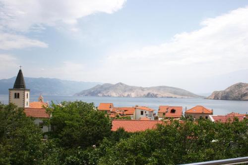 a town with a view of the water and mountains at Apartments Crnekovic Tomislava 8 in Baška