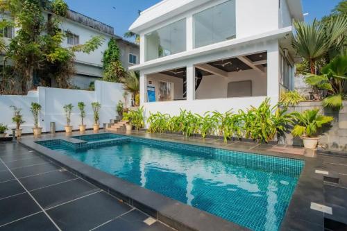 an image of a swimming pool in front of a house at Lavish Apartments with Pool Candolim Luxfort in Candolim