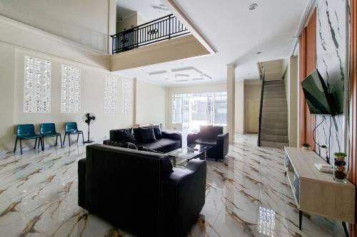 a living room with a couch and a table at Sans Hotel Bliss Pekanbaru in Sultan Syarif Kasim II International Airport