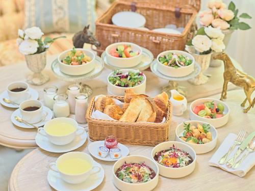 a table topped with dishes of food and a basket of bread at Auberge de Primavera in Karuizawa