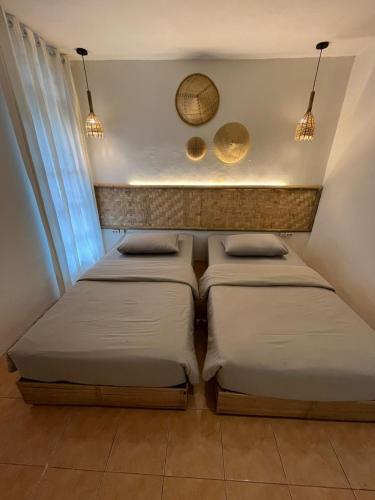 two beds in a small room with lights at Stay and Farm Hostel in Ciwidey