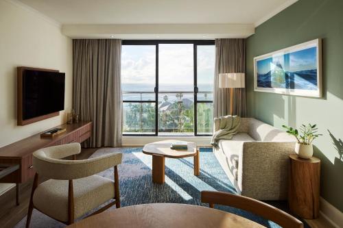 a living room with a couch and a large window at President Hotel in Cape Town