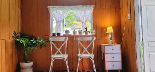 a room with two chairs and a window at Poong's Garden Mộc Châu in Mộc Châu