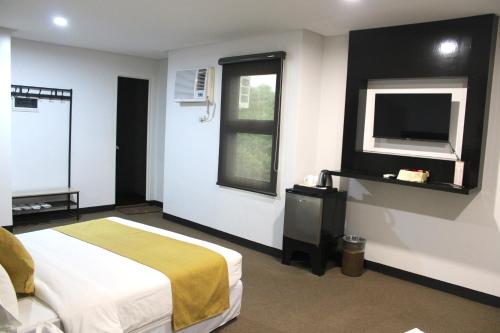Televisyen dan/atau pusat hiburan di Belvilla Cozy Stays Near Airport Formerly Boss Hotel