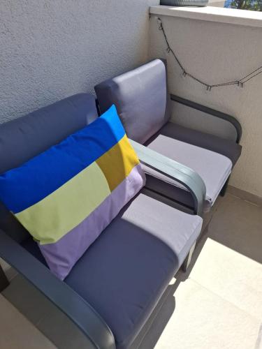 a blue bench with a colorful pillow on it at Graceful LJUPKA GETAWAY by the sea - Lokva Rogoznica, Omiš in Lokva Rogoznica