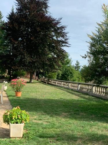 a fence in a park with flowers in the grass at Un petit coin de Paradis in Lalley