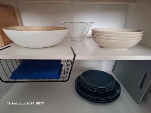 a shelf with two bowls and plates on it at Graceful LJUPKA GETAWAY by the sea - Lokva Rogoznica, Omiš in Lokva Rogoznica