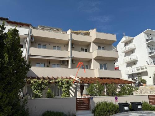 a large apartment building with an orange arrow on it at Graceful LJUPKA GETAWAY by the sea - Lokva Rogoznica, Omiš in Lokva Rogoznica