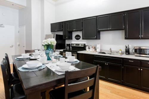a kitchen with black cabinets and a table with chairs at Gaslamp 2bdrm1ba - W Parking & 4 Beds #304 in San Diego