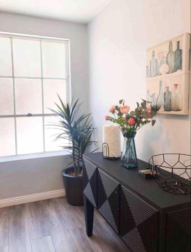 a room with a table with flowers and a window at 2bdrm Gaslamp Conv Cntr - W Parking & 5 Beds #3 in San Diego